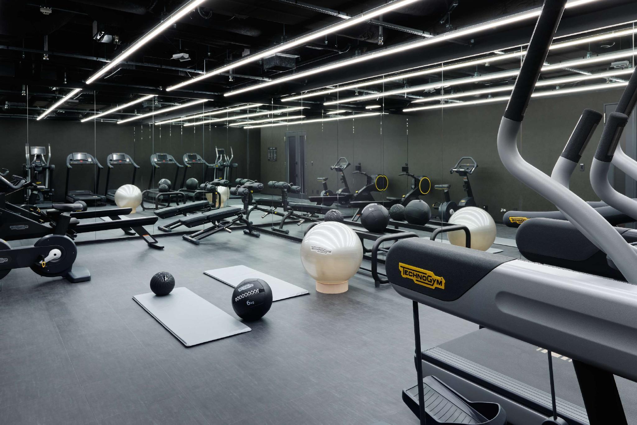 Mitsui Garden Hotel Roppongi Tokyo Premier Eksteriør billede The photo shows a modern gym interior. The space features various exercise equipment, including cardio machines like treadmills and elliptical trainers, weight machines, and free weights. There are also exercise mats and fitness balls scattered throu